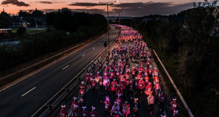 People in pink tops and flashing bunny ears participating in Sparkle Night Walk