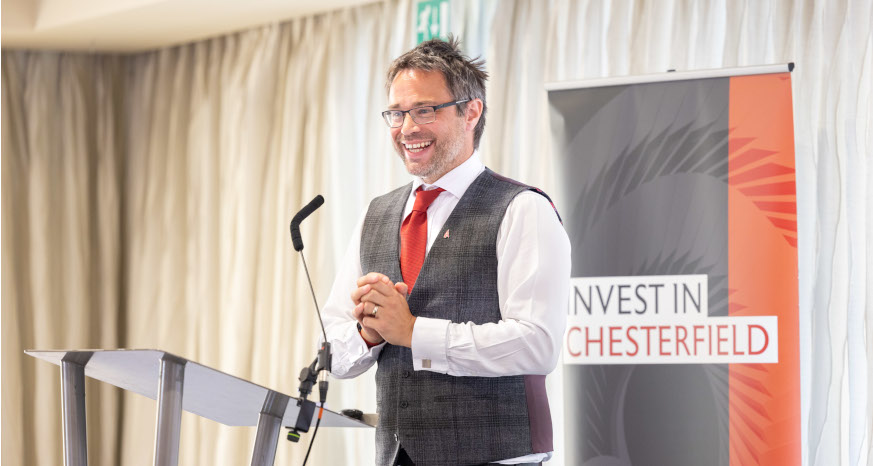 Man in waistcoat stood in front of sign saying 'Invest in Chesterfield'