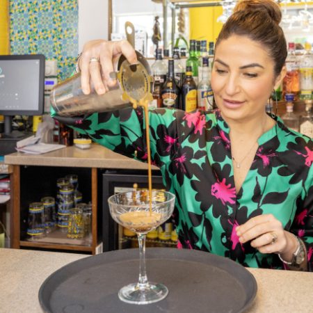 Monica from Sicily Restaurant pouring a coffee cocktail from a height into a glass