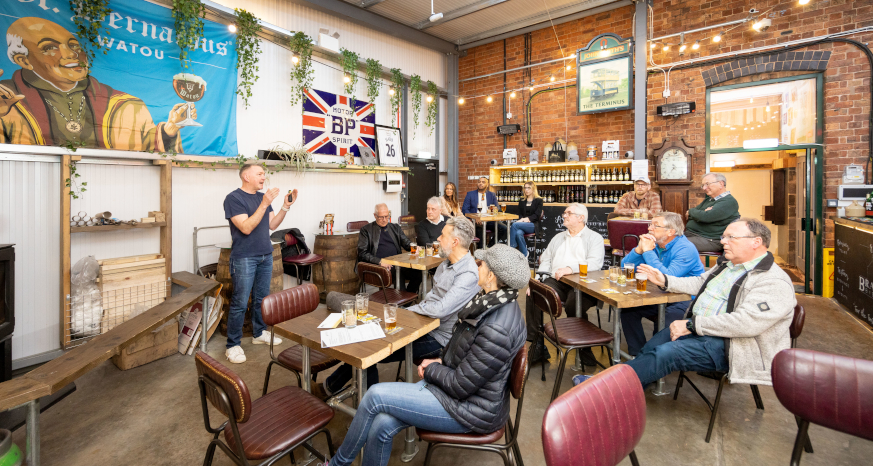 Chris Radford, Head Brewer presenting to a full room of seated guests at the brewery bar