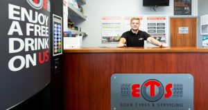 Male employee behind counter, sign in front for Eden Tyres and Servicing, Chesterfield