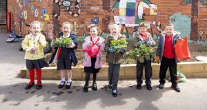 Six pupils holding their plants in the garden at Heath Primary School