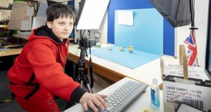 Young white learner using computer and camera to film animation using minions