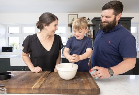 Mum, Dad and child in kitchen smiling