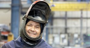 Engineer with protective helmet open, smiling at Weightron