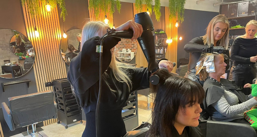 Woman in a salon drying another woman's hair