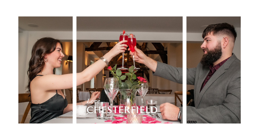 Valentine's table decorations with couple (male and female) in evening wear saying cheers with red champagne glasses