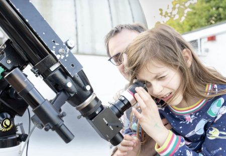 Child looking through a telescope