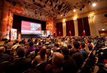 Large audience looking at slide that says 'evolving' at the celebrate chesterfield 2024 conference