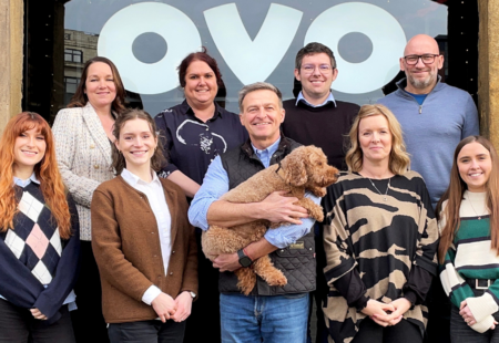 Group of 9 people and a cockapoo dog outside of ovo spaces