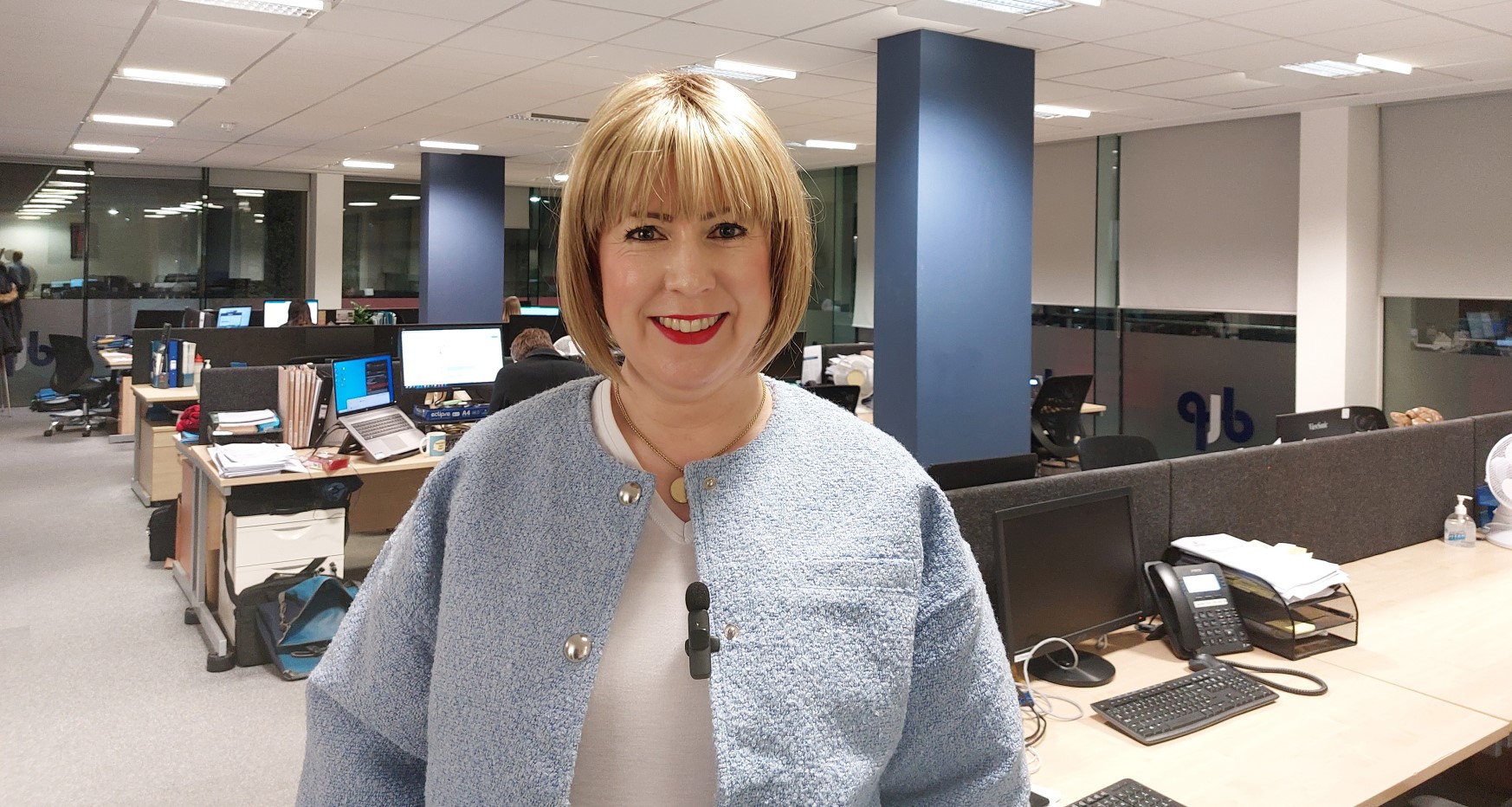 Anna Meer stood in office smiling to camera