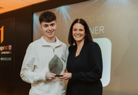 Apprentice with manager holding award trophy