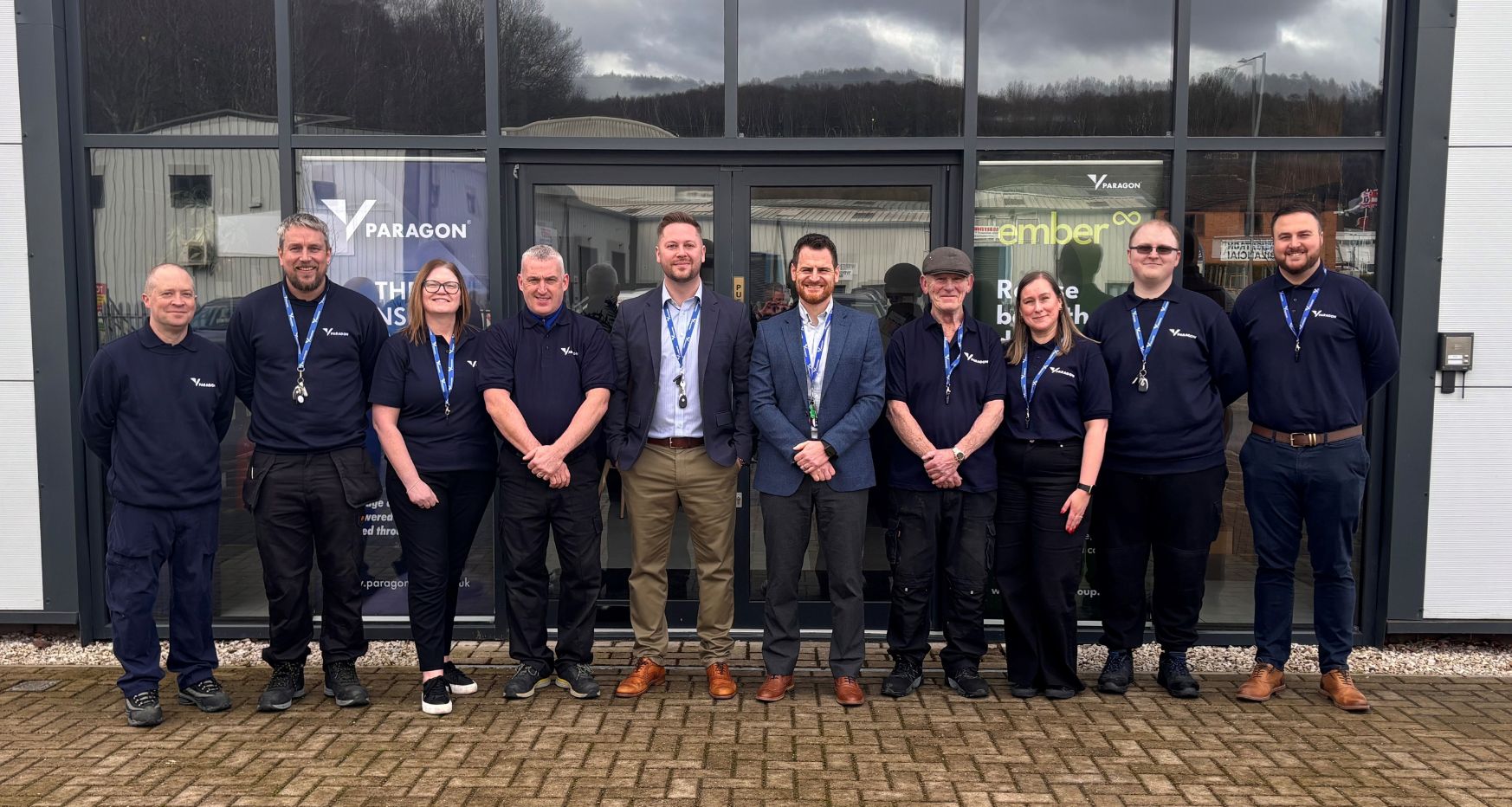 A mixed group of 10 males and females stood asmiling outside of the paragon products building