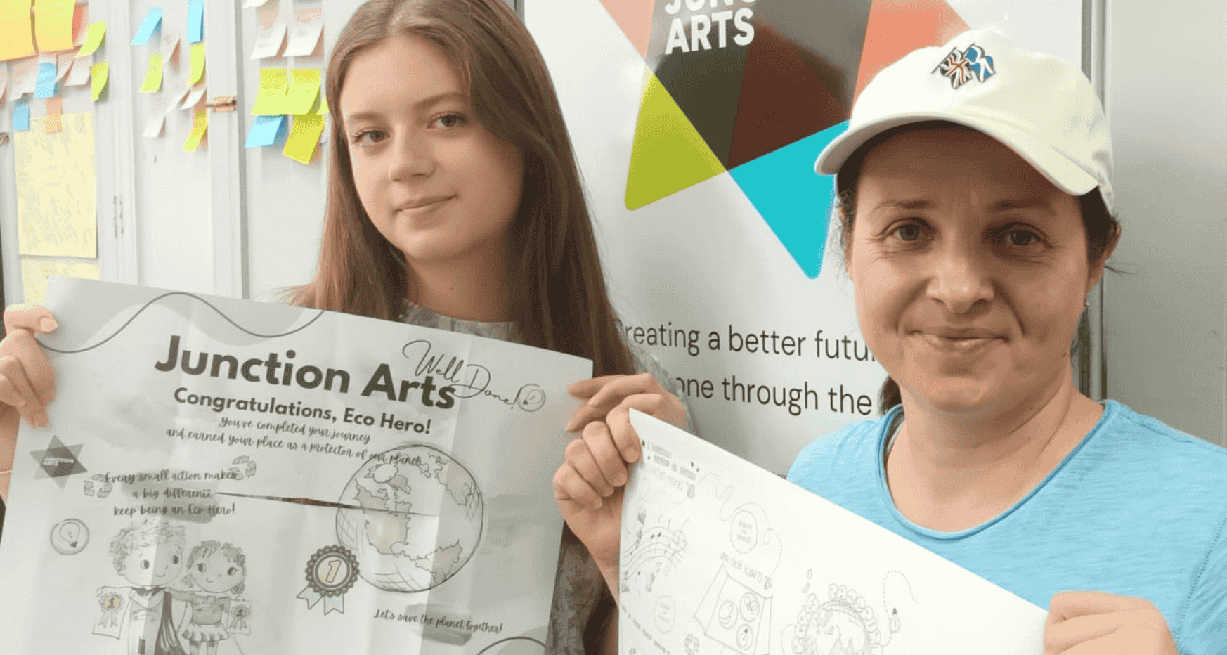 Two females holding up art