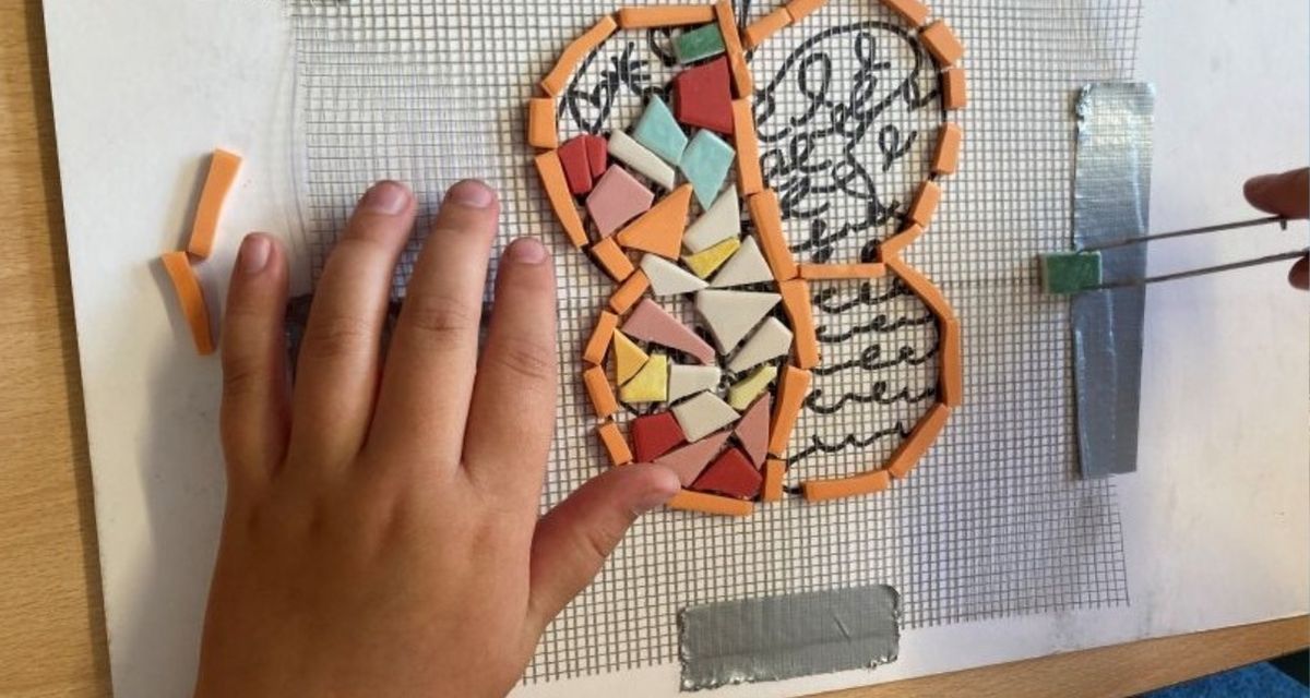 Student working on mosaic for the sculpture.