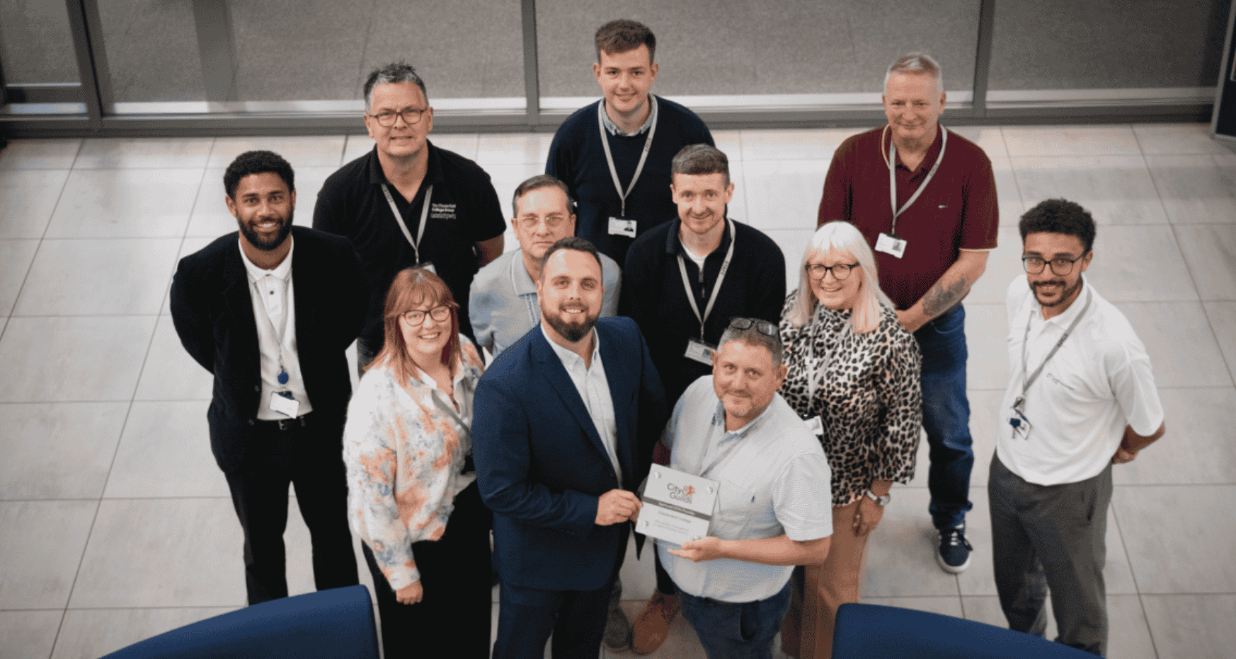 Professionals from Chesterfield College in a group, two people in foreground holding award