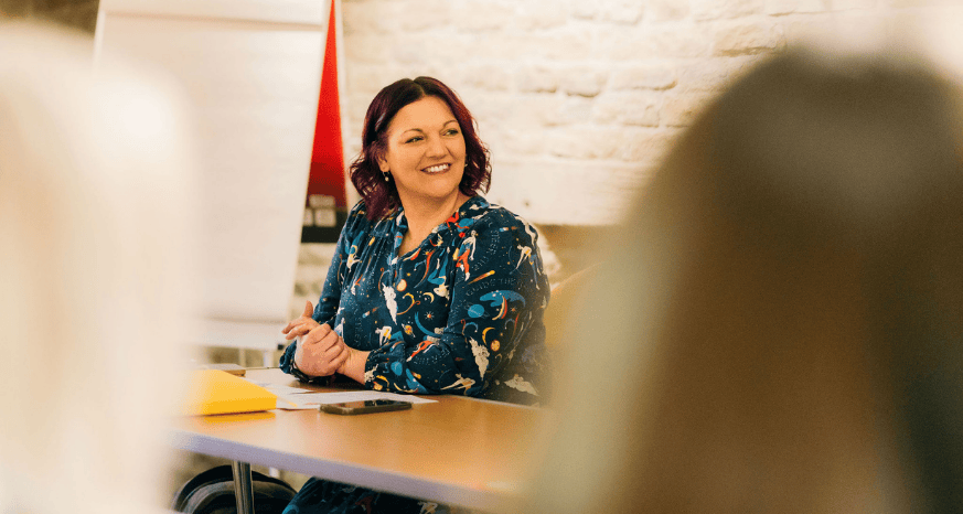 Female business leader at table, smiling